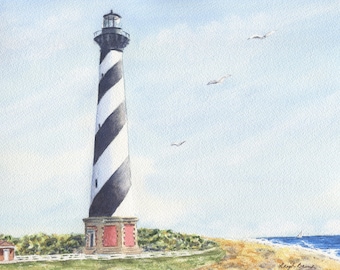 May include: Watercolor painting of a tall lighthouse with black and white spiral stripes. The lighthouse stands on a sandy beach with a small red building and green foliage. Three seagulls fly in the sky above the lighthouse.
