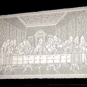 Può includere: Tovaglia da tavola in crochet bianco con una rappresentazione dell'Ultima Cena. La tovaglia presenta un design dettagliato di un tavolo con 13 figure sedute intorno.