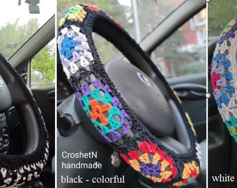 May include: Three crocheted steering wheel covers. The first is black with white accents. The second is black with colorful squares. The third is white with colorful squares. All three covers have the text "CroshetN handmade" on them.