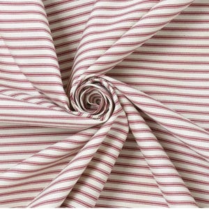 Könnte beinhalten: Nahaufnahme eines Stoffes mit einem sich wiederholenden Muster aus dünnen, horizontalen Streifen in einem gedämpften Rotton vor einem cremefarbenen Hintergrund. Der Stoff ist gerafft und gefaltet, wodurch ein strukturierter Look entsteht. Das Material ist wahrscheinlich Baumwolle oder Leinen.