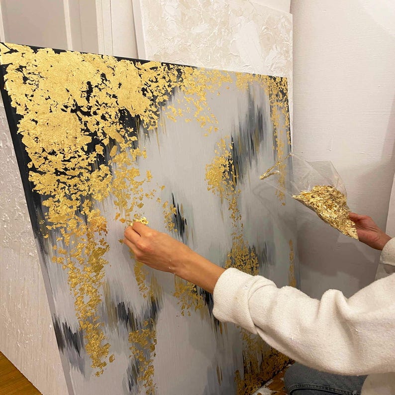 Gold foil painting with shimmering metallic details for a sophisticated living room aesthetic