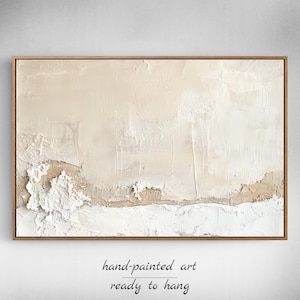 May include: Abstract hand-painted artwork in a wooden frame. The piece has a textured, layered design with beige, white, and brown tones. The text "hand-painted art ready to hang" is at the bottom.