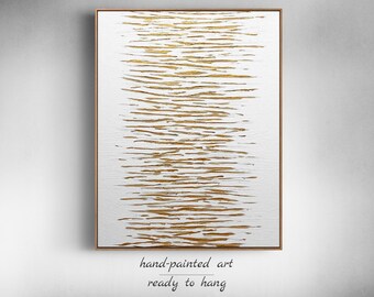 May include: Abstract painting with gold and white stripes on a canvas. The painting is framed and ready to hang.