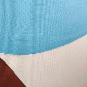 May include: Close-up of a painting with a blue, white, and brown color scheme. The blue paint is applied in a thick, textured layer, while the white and brown paint are applied in a smoother layer.