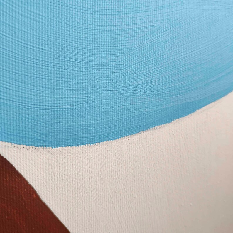 May include: Close-up of a painting with a blue, white, and brown color scheme. The blue paint is applied in a thick, textured layer, while the white and brown paint are applied in a smoother layer.