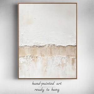 May include: Abstract painting with a textured white background and a horizontal band of beige paint. The painting is framed in a thin, wooden frame.