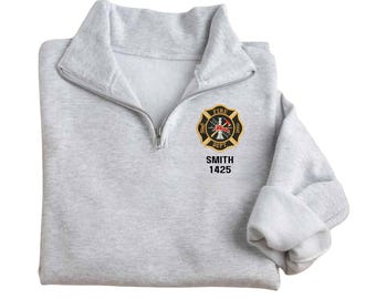 May include: A gray 1/4 zip sweatshirt with a black embroidered firefighter badge and the text "FIRE DEPT" and "SMITH 1425".