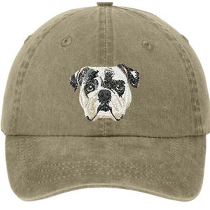 Könnte beinhalten: Eine khaki-grüne Baseballkappe mit einem gestickten Bild eines schwarz-weißen Bulldoggen.
