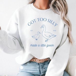 May include: White sweatshirt with a blue graphic design that says "GOT TOO SILLY EST. 2025 made a little goose" with two geese illustrations.