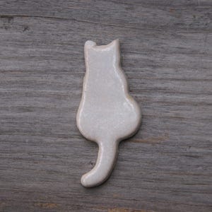 white Cat with a tail fridge magnet.
