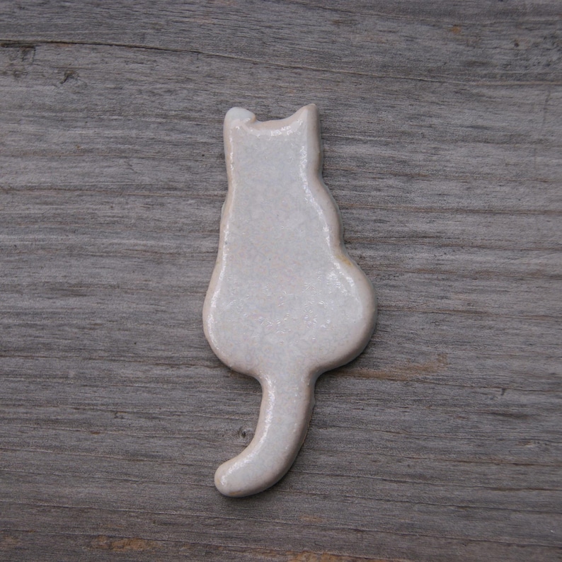 white Cat with a tail fridge magnet.