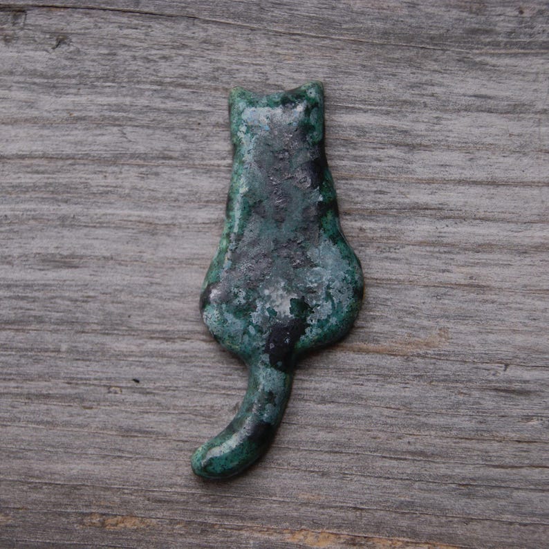 green Cat with a tail fridge magnet.