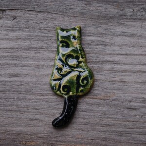 green Cat with a tail fridge magnet.