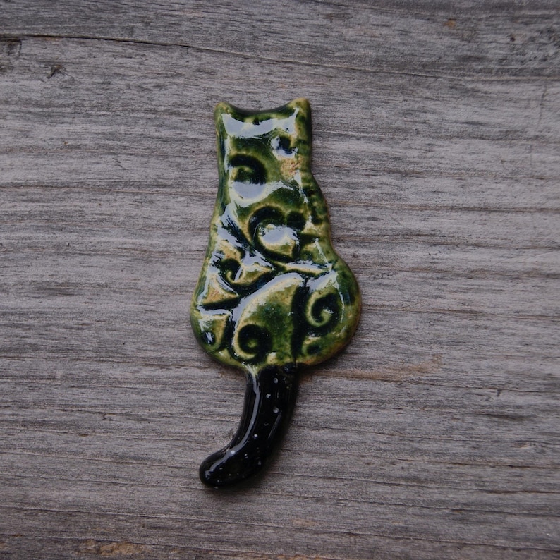 green Cat with a tail fridge magnet.