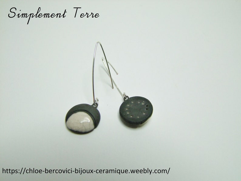 pointed,stuck Ceramic earring white Raku clocked by black.