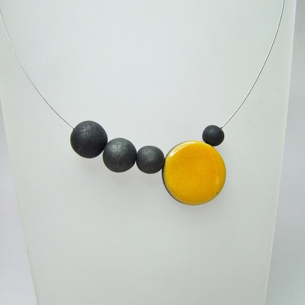 Collana in ceramica Raku, perle nere fumose e perla piatta gialla.