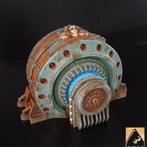 May include: A rusty, blue and brown metal gear with a skull on top. The gear has a large, circular center with a smaller, circular gear inside. The gear is on a black background.