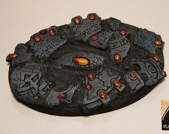 May include: A circular, gray, stone-like base with a cracked surface and orange gems embedded in it. The base has a design of runes and symbols.