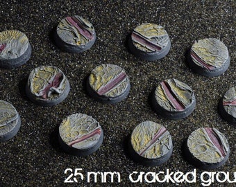 May include: Twelve 25 mm round plastic bases with a cracked ground texture. The bases are painted in shades of yellow, gray, and red.