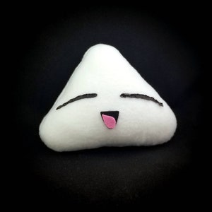 May include: A white plush triangle-shaped pillow with a smiling face. The pillow has black eyes and a pink mouth.