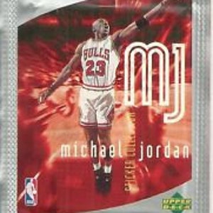 May include: A silver foil trading card featuring a red, orange, and yellow background with a silhouette of Michael Jordan in a red and white Chicago Bulls jersey. The card features the text "MJ" in large, bold letters and "Michael Jordan" in smaller letters below.