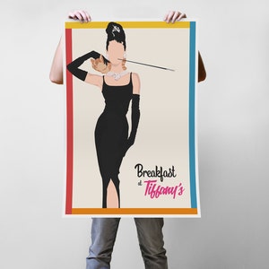 May include: A poster featuring a stylized illustration of a woman in a black dress, long gloves, and a pearl necklace, holding a cigarette holder. The text "Breakfast at Tiffany's" is displayed in pink and black. The poster has a cream background with a red, orange, and blue border.
