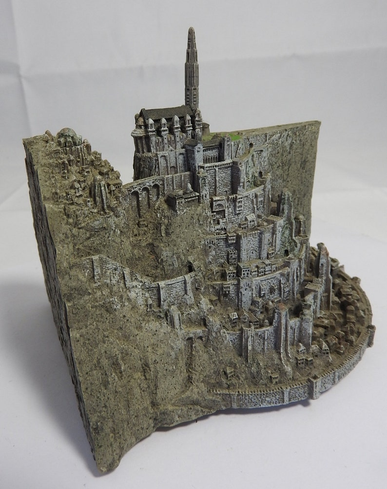 vintage resin small gray ornament paperweight of the town in the rocks with a platform for the plane