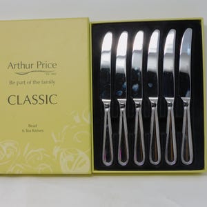 Könnte beinhalten: Ein Set von sechs Teemessern in einer Schachtel. Die Messer haben silberne Klingen und Griffe mit einem Perlendesign. Die gelbe Schachtel trägt den Text "Arthur Price CLASSIC Bead 6 Tea Knives".