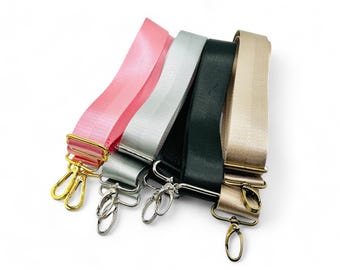 May include: Four different colored straps with gold and silver clasps. The straps are pink, silver, black, and gold.