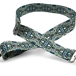 May include: A white and blue patterned adjustable strap with silver swivel clips. The strap is made of fabric and has a repeating pattern of swirls and circles.