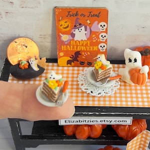 May include: A miniature Halloween scene with a small cake decorated with a ghost and pumpkins, a ghost holding a pumpkin, and a sign that says "Trick or Treat, Happy Halloween".