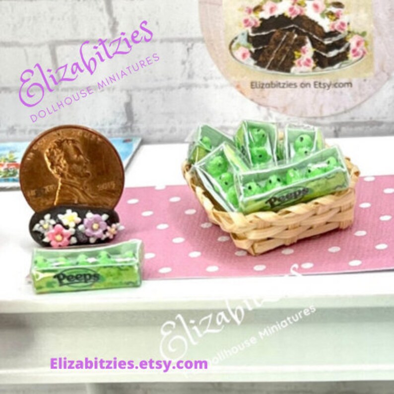 May include: A miniature basket filled with green Peeps candy, a miniature box of Peeps candy, and a miniature US penny. The items are on a pink and white polka dot surface.