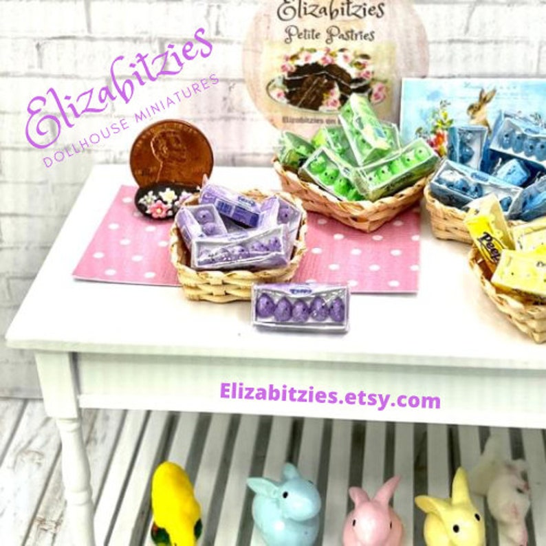 May include: A miniature dollhouse shop display featuring a variety of pastel-colored Easter eggs in small wicker baskets. The shop is called "Elizabitzies Dollhouse Miniatures" and the website is "Elizabitzies.etsy.com".