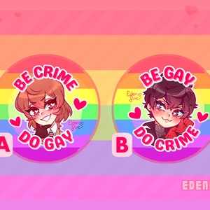 Op de afbeelding: Twee ronde knoppen met regenboogachtergronden en witte tekst. De tekst op de linkerknop luidt "BE CRIME DO GAY" en toont een cartoonfiguur met bruin haar. De tekst op de rechterknop luidt "BE GAY DO CRIME" en toont een cartoonfiguur met zwart haar. Beide knoppen hebben een roze hart in de rechterbovenhoek en de tekst "EDEN FIRE" in de rechterbenedenhoek.
