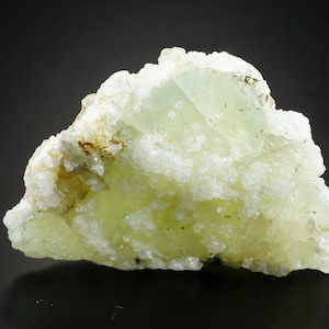 May include: A cluster of light green fluorite crystals with a white, crystalline matrix. The fluorite crystals have a glassy luster and are translucent.