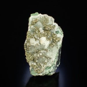 May include: A natural mineral specimen with a pale green and white stone matrix, dotted with clusters of golden pyrite crystals. The rough edges and varied textures create a striking display.