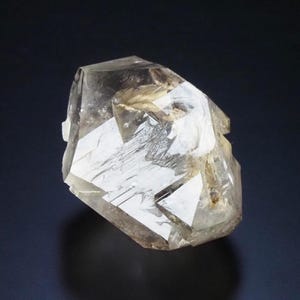 May include: A clear quartz crystal with multiple facets, displaying a natural, geometric form. The crystal is translucent, with subtle colour and texture variations. The overall appearance is a blend of clarity and natural imperfections, highlighting its geological origin.