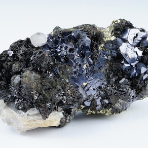 May include: A cluster of grey and black crystals with a hint of gold. The crystals are arranged in a rough, natural formation.