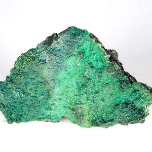 May include: A textured mineral specimen, irregularly shaped, with a striking colour palette. The stone features bright and dark green shades, with touches of blue. The edges are dark and rough, contrasting with the vivid green centre.