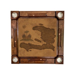 May include: A square, wooden domino table with a map of Haiti in the center. The table has a dark brown finish, with four metal cup holders and storage for dominoes. The map is in shades of brown and tan, with a compass rose and a coat of arms.