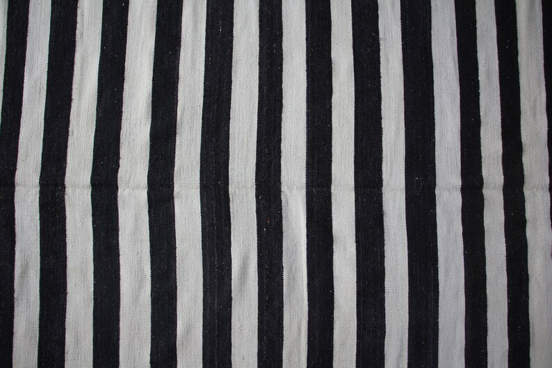 May include: Black and white striped fabric with a woven texture.