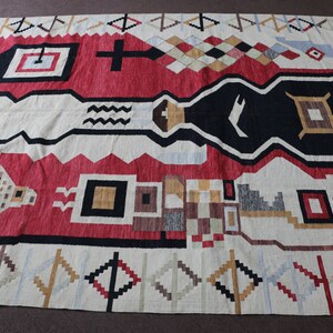 Puede incluir: Una alfombra geom&eacute;trica colorida con un patr&oacute;n rojo, negro, blanco y beige. La alfombra tiene un dise&ntilde;o tradicional con detalles intrincados.