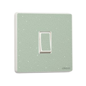 Puede incluir: Una tapa de interruptor de luz con un patrón verde moteado. La tapa tiene un interruptor de luz blanco y el texto "stika.co" en la esquina inferior derecha.