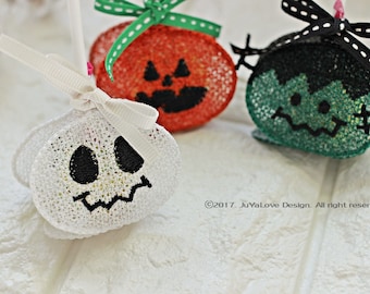 May include: Three Halloween-themed decorations: a white ghost, an orange pumpkin, and a green Frankenstein's monster. Each is made of a mesh-like material with embroidered facial features and a ribbon bow. The ghost has a white bow, the pumpkin has a green bow, and the monster has a black bow.