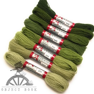 May include: A set of ten green embroidery floss spools with the brand name "Appletons" and the spool number printed on each. The spools are arranged in a gradient from dark green to light green.