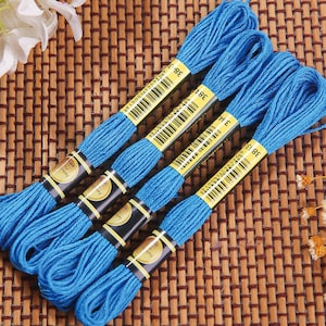 May include: Four spools of blue embroidery floss with black and gold labels. The labels have barcodes and the number 38 printed on them.