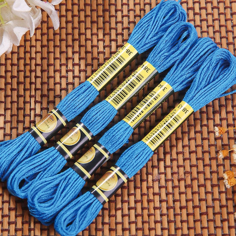 May include: Four spools of blue embroidery floss with black and gold labels. The labels have barcodes and the number 38 printed on them.
