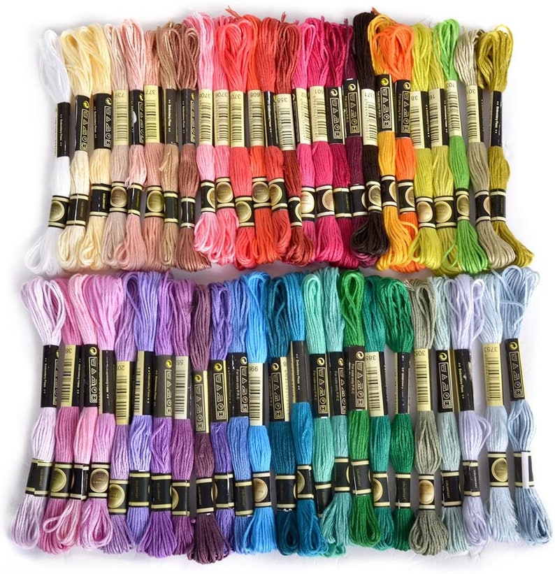 May include: A collection of 50 embroidery floss spools in a variety of colors, including pink, purple, blue, green, yellow, orange, red, and brown. Each spool is labeled with the brand name "Anchor" and a number.
