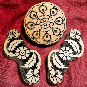 May include: Three wooden block printing stamps with intricate floral designs. The stamps are carved with detailed patterns and are ready to be used for creating unique prints.