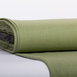 May include: A roll of green linen fabric, folded and displayed on a white surface. The fabric is smooth and has a subtle texture.